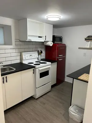 a kitchen with white appliances and a red refrigerator at Merritt Place Niagara in St. Catharines