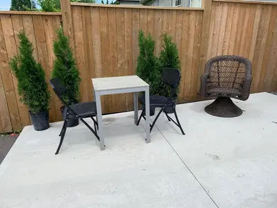 a white table and two chairs and a fence at Merritt Place Niagara in St. Catharines