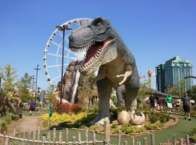 a dinosaur statue in front of a ferris wheel at Merritt Place Niagara in St. Catharines