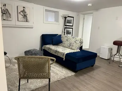 a living room with a blue couch and a chair at Merritt Place Niagara in St. Catharines