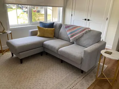 a grey couch with pillows on it in a living room at The Loft Retreat in Southampton