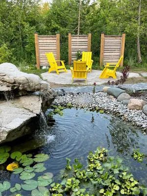 two yellow chairs sitting next to a pond at The Loft Retreat in Southampton