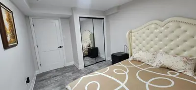 a bedroom with a large bed and a mirror at Entire 2 Bedroom Apartment in Kitchener in Kitchener
