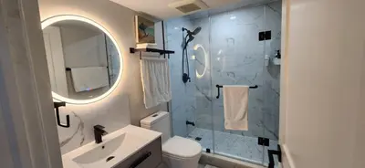 a bathroom with a sink and a shower with a mirror at Entire 2 Bedroom Apartment in Kitchener in Kitchener
