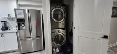 a kitchen with a refrigerator and a washer and dryer at Entire 2 Bedroom Apartment in Kitchener in Kitchener
