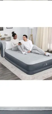 a man and a woman sitting on a mattress at Entire 2 Bedroom Apartment in Kitchener in Kitchener