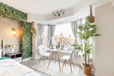a bedroom with a table and chairs in front of a window at Yorkville Plaza Express Stay in Toronto