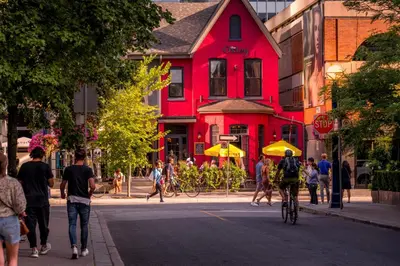 a group of people crossing a street in front of a red building at Yorkville Plaza Express Stay in Toronto