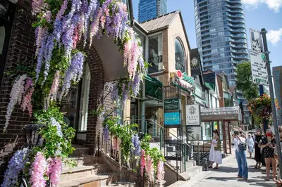 a street with purple wisteria hanging from a building at Yorkville Plaza Express Stay in Toronto