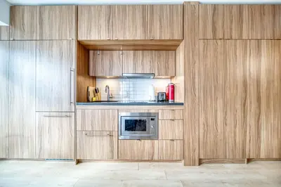 a kitchen with wooden cabinets and a microwave at Yorkville Plaza Express Stay in Toronto