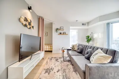 a living room with a couch and a flat screen tv at Yorkville Plaza Express Stay in Toronto