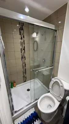 a bathroom with a toilet and a glass shower at Bishop in Mississauga