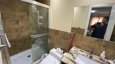 a man taking a picture of a bathroom at Bishop in Mississauga