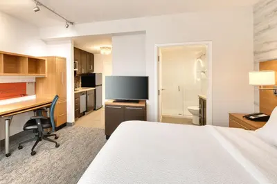 a hotel room with a bed and a desk and a television at TownePlace Suites by Marriott Belleville in Belleville