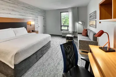 a hotel room with a bed and a couch at TownePlace Suites by Marriott Belleville in Belleville