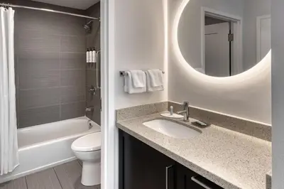 a bathroom with a sink and a toilet and a mirror at TownePlace Suites by Marriott Belleville in Belleville