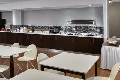 a restaurant with white tables and a counter at TownePlace Suites by Marriott Belleville in Belleville