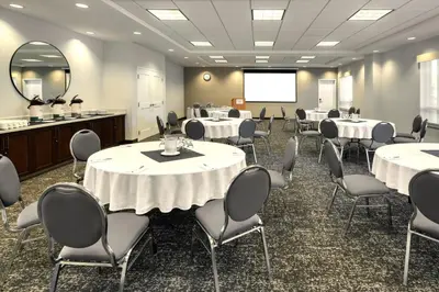 a conference room with tables and chairs and a projection screen at TownePlace Suites by Marriott Belleville in Belleville