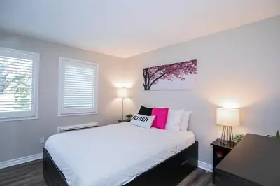 a bedroom with a white bed with pink pillows at Mountainside Retreat in Blue Mountains