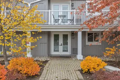 a gray house with a balcony and a patio at Whispering Pines Escape in Collingwood