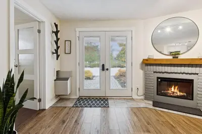 a living room with a fireplace and a mirror at Whispering Pines Escape in Collingwood