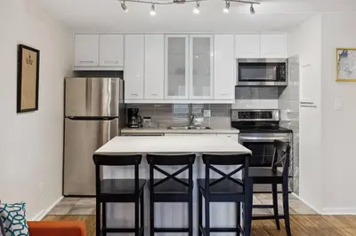 a kitchen with a stainless steel refrigerator and bar stools at Whispering Pines Escape in Collingwood