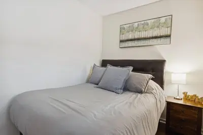 a bedroom with a large bed with blue pillows at Whispering Pines Escape in Collingwood