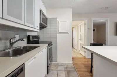 a kitchen with white cabinets and a sink at Whispering Pines Escape in Collingwood