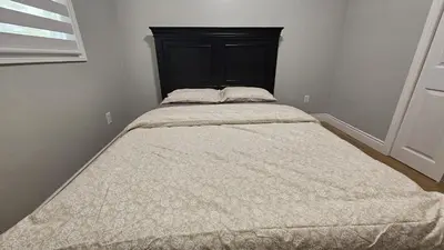 a bed with a black headboard in a bedroom at Home in Niagara region in St. Catharines