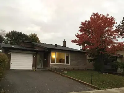 a house with a garage and a tree at Private Rooms, Free Parking, Full Kitchen, Best Prices in Town- York University Heights in Toronto