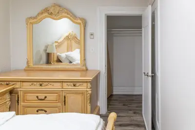 a bedroom with a dresser with a mirror on it at Downtown Apartment 6-7 people in Bowmanville