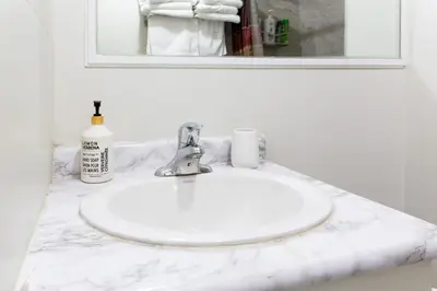 a bathroom sink with a white marble counter top at Downtown Apartment 6-7 people in Bowmanville