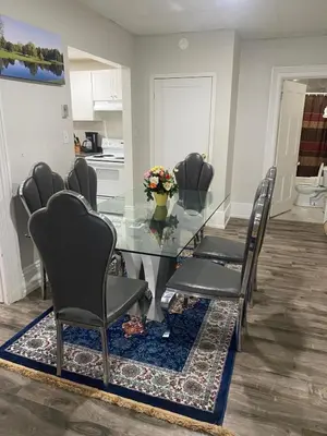 a dining room with a glass table and chairs at Downtown Apartment 6-7 people in Bowmanville