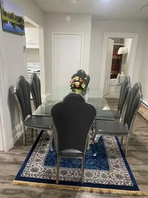 a dining room with a glass table and chairs at Downtown Apartment 6-7 people in Bowmanville