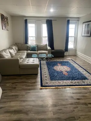 a living room with a couch and a rug at Downtown Apartment 6-7 people in Bowmanville