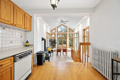 a kitchen with wooden cabinets and a dining room at Picturesque & Serene Gem in Port Credit - Steps to Lake - Backyard in Mississauga