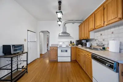 a large kitchen with wooden cabinets and white appliances at Picturesque & Serene Gem in Port Credit - Steps to Lake - Backyard in Mississauga