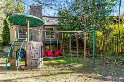 a playground in a yard with a play structure at Hot Tub Haven in Toronto