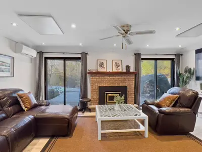 a living room with leather furniture and a fireplace at Hot Tub Haven in Toronto