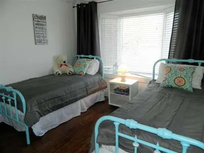 a bedroom with two beds and a teddy bear on the bed at Cute and Cozy Lakefront Cottage in Wellington