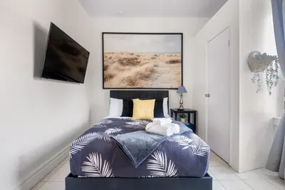 a bedroom with a bed with a blue comforter at Stylish & Inviting Private Bedroom in Corso Italia in Toronto