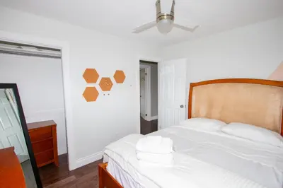 a bedroom with a bed with white sheets and a fan at Deer Run Cottage- Golf Course cottage in Kawartha Lakes