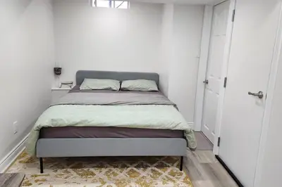 a bed in a white room with a bed sidx sidx sidx at Moons & Noons -Separate Unit for your Comfort in Ajax