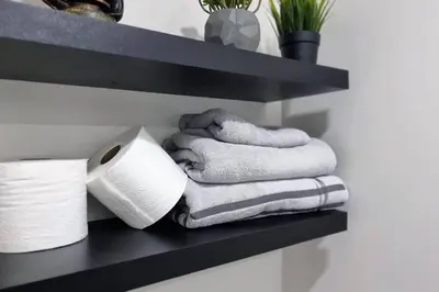 a shelf with towels and a roll of toilet paper at Moons & Noons -Separate Unit for your Comfort in Ajax