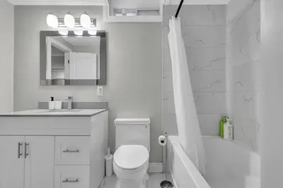 a white bathroom with a toilet and a sink at Cosy Guest Suite Near Shops, Transit, Hwy and GO! in Mississauga
