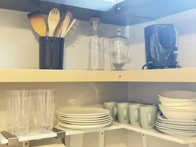 a shelf with plates and other dishes on it at Cosy Guest Suite Near Shops, Transit, Hwy and GO! in Mississauga