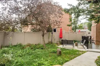 a yard with a fence and a bench and a tree at Cosy Guest Suite Near Shops, Transit, Hwy and GO! in Mississauga