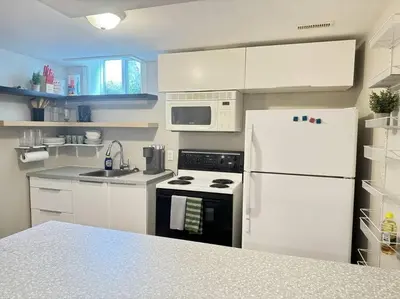 a kitchen with white cabinets and a white refrigerator at Cosy Guest Suite Near Shops, Transit, Hwy and GO! in Mississauga