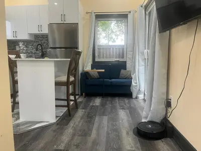 a kitchen and a living room with a blue couch at The Grassy Oasis in Brampton