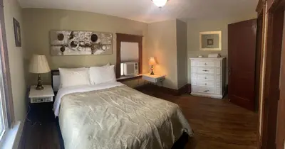 a bedroom with a bed and a white dresser at Exceptionally Close to the Falls Amazing Location & Complimentary Breakfast Delivered Daily to the Rental in Niagara Falls